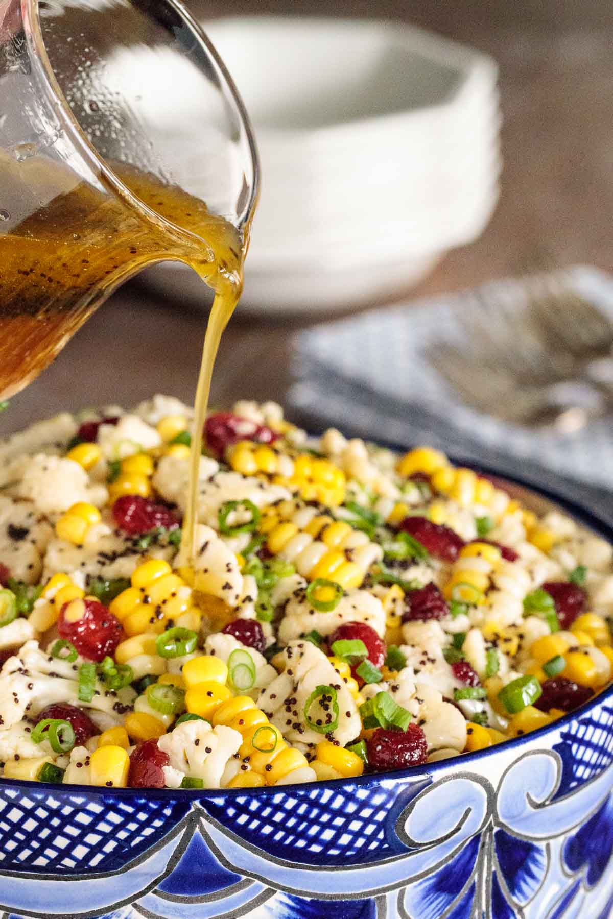Vertical picture of cauliflower and corn salad in a blue and white bowl