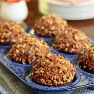 Vertical photo of Praline Pumpkin Muffins in a blue porcelain muffin pan.
