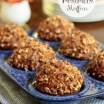 Vertical photo of a batch of Easy Praline Pumpkin Muffins in a blue patterned muffin pan.