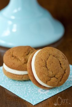Vertical picture of two Pumpkin Whoopie Pies with Bourbon Brown Butter Buttercream on a light blue and white napkin