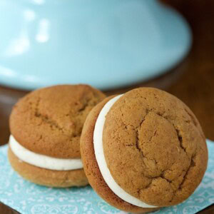 Vertical picture of two Pumpkin Whoopie Pies with Bourbon Brown Butter Buttercream on a light blue and white napkin