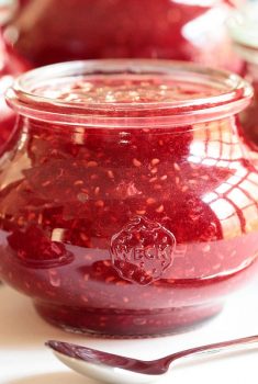 Horizontal closeup photo of a batch of Red Raspberry Freezer Jam in glass Weck jars.