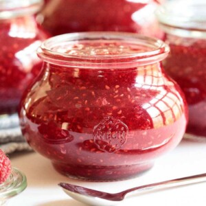 Horizontal closeup photo of a batch of Red Raspberry Freezer Jam in glass Weck jars.
