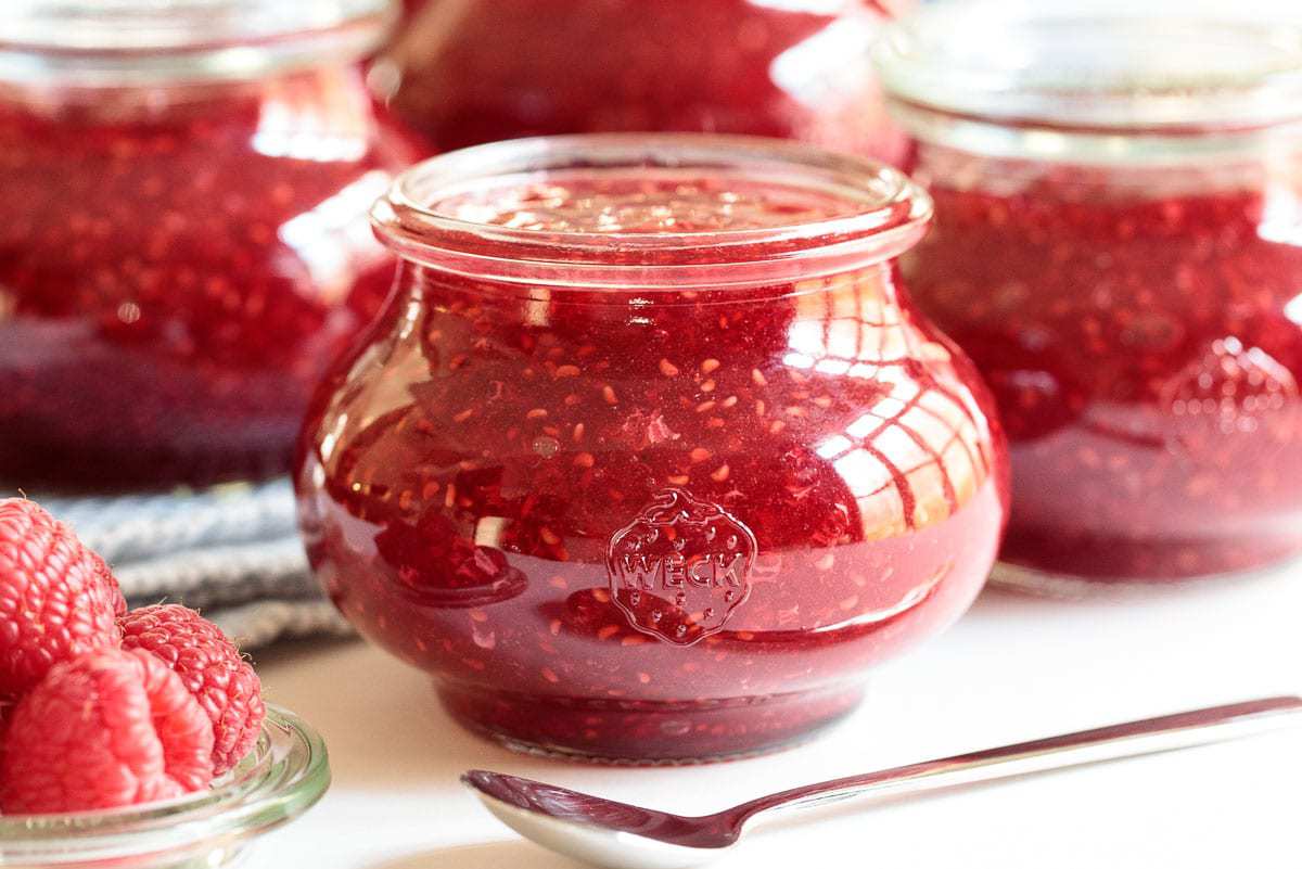 Horizontal closeup photo of Weck jars filled with Easy Raspberry Freezer Jam.