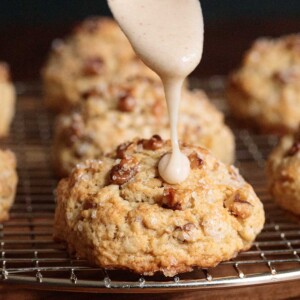 Vertical picture of banana bread scones on a cooling rack with icing drizzled on top
