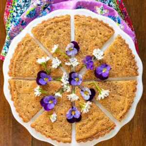 Overhead picture of Brown Sugar Shortbread cut into wedges, decorated with purple and white flowers