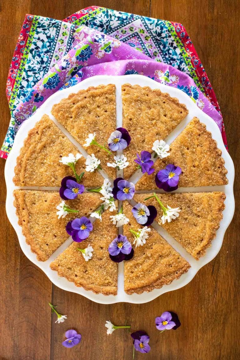 Overhead picture of Brown Sugar Shortbread cut into wedges, decorated with purple and white flowers
