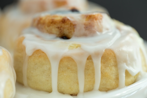 A closeup shot of a Ridiculously Easy Cinnamon Roll with the glaze drizzling down the side.