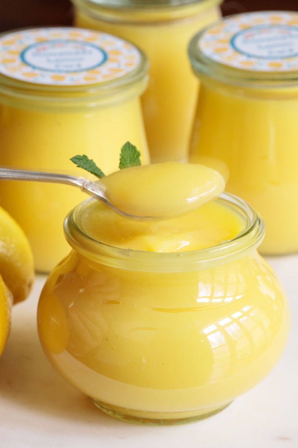 Vertical closeup photo of homemade Ridiculously Easy Microwave Lemon Curd in glass Weck jars.
