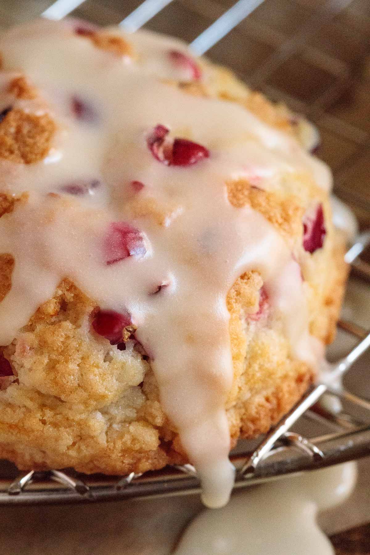 Vertical extreme closeup photo of a Ridiculously Easy Orange Cranberry Scone freshly topped with orange icing.
