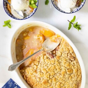Overhead picture of Easy Peach Crumble scooped into small bowls with ice cream.