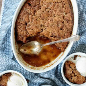 Overhead picture of sticky toffee pudding in a large white dish, served in smaller white bowls with icecream