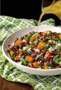 Vertical picture of Roasted Butternut Salad in a white bowl on a green and white napkin