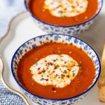 Vertical picture of Roasted Red Pepper Tomato Soup in blue and white bowls