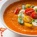 Close up vertical picture of Roasted Tomato Lentil Soup Caprese in a white bowl