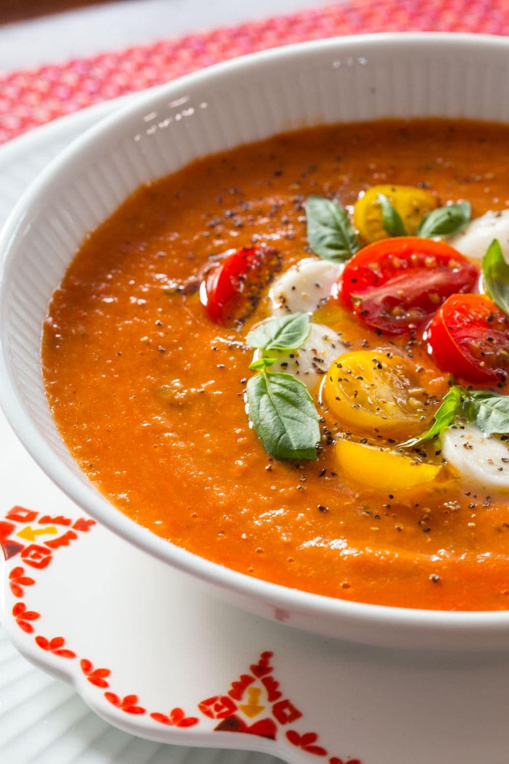 Close up picture of Roasted Tomato Lentil Soup Caprese in a white bowl