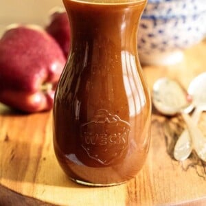 Vertical picture of apple cider caramel sauce in a glass jar