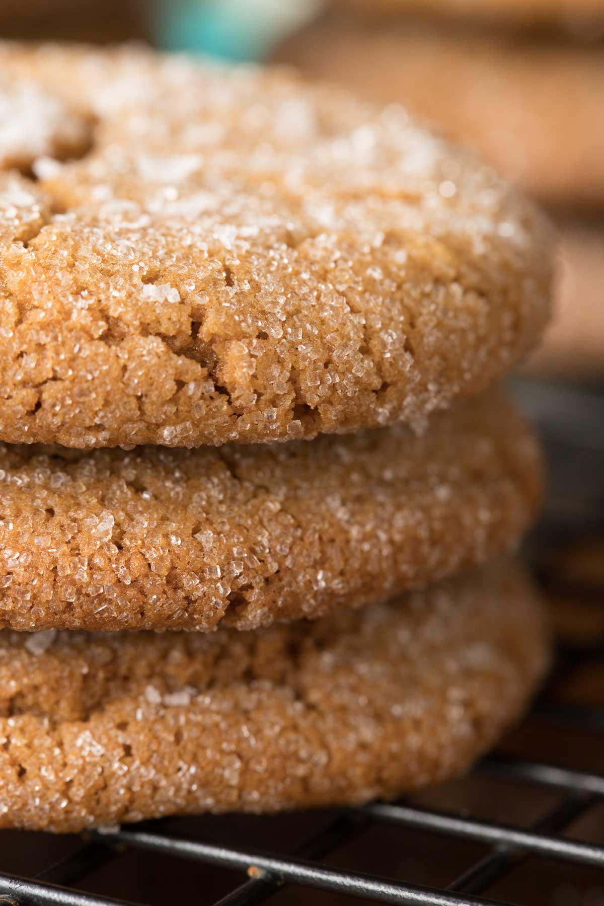 Ultra closeup photo of a stack of Sea Salted Brown Sugar Cookies featuring the edges of the cookies on a black cooling rack.