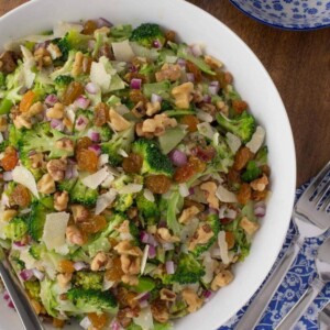 Close up overhead picture of shaved broccoli salad in a white bowl