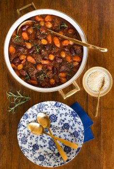 Overhead vertical photo of a pot of Slow Braised Italian Beef Stew on a wood table.