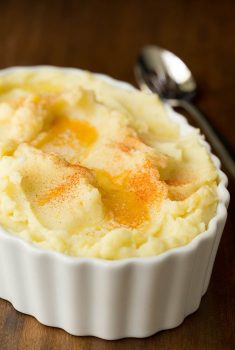 Vertical picture of slow cooker mashed potatoes in a white dish