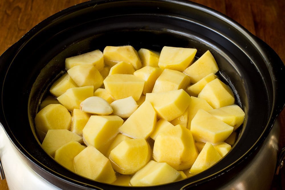 Prep photo of a pot of Slow Cooker Buttermilk Mashed Potatoes before they are cooked.