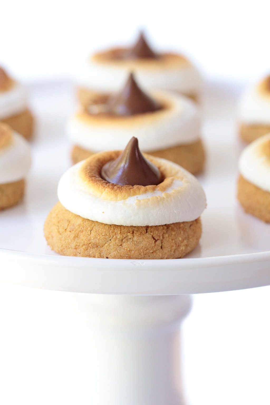Vertical picture of S'mores Blossom Cookies on a white cakestand