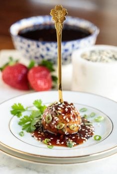 Vertical photo of Strawberry Balsamic Glazed Chicken Meatballs on a white plate.