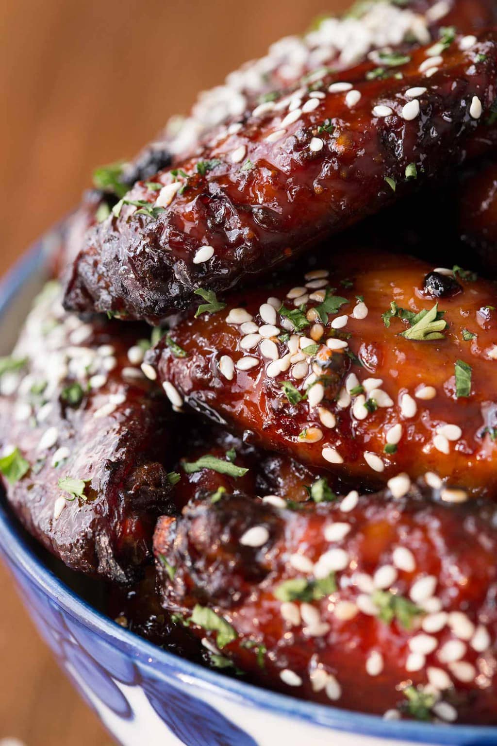 Closeup photo of a blue and white patterned bowl filled with Strawberry Balsamic Baked Wings.