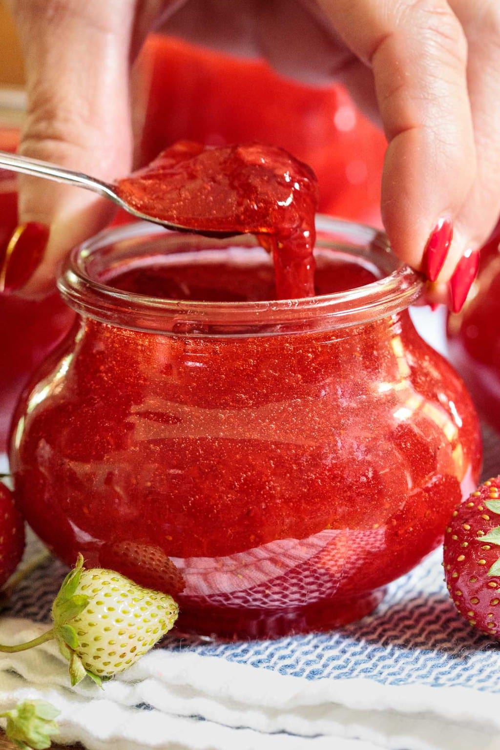 Vertical closeup photo of Strawberry Freezer Jam in glass Weck jars.