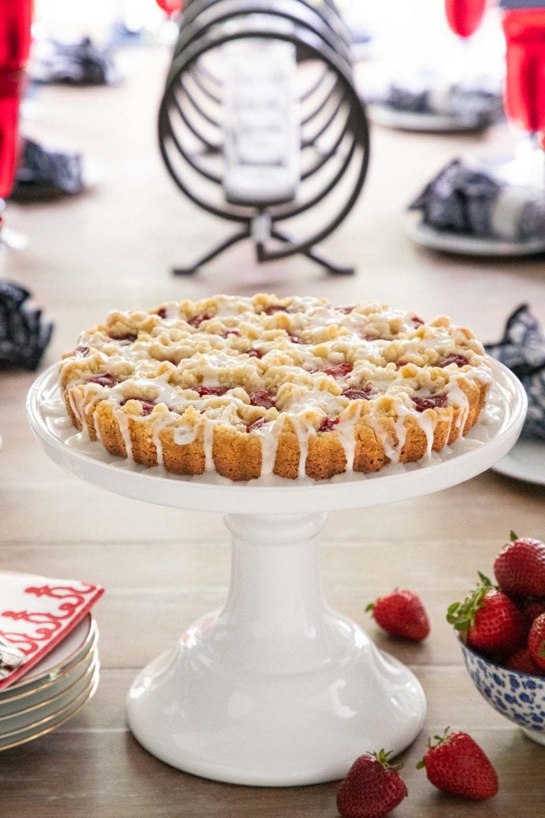 Vertical picture of strawberry jam shortbread tart on a white cake stand