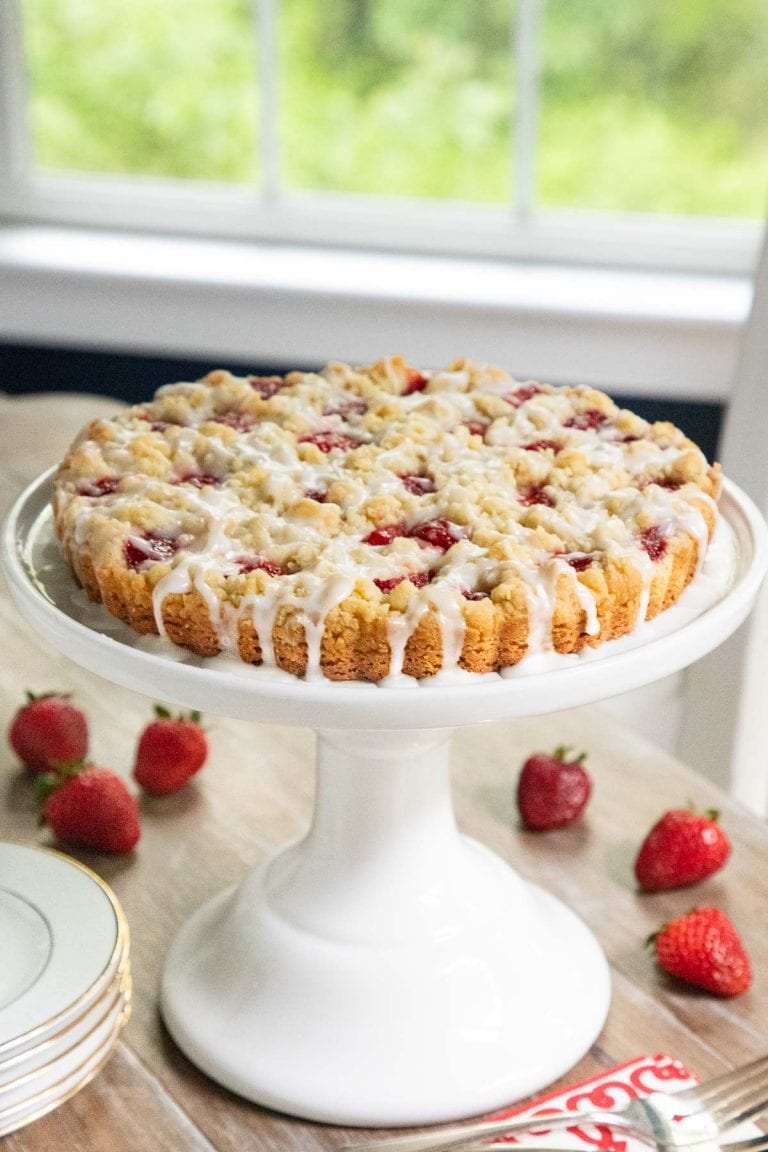 Strawberry Shortbread Tart on a white cake stand with fresh berries.