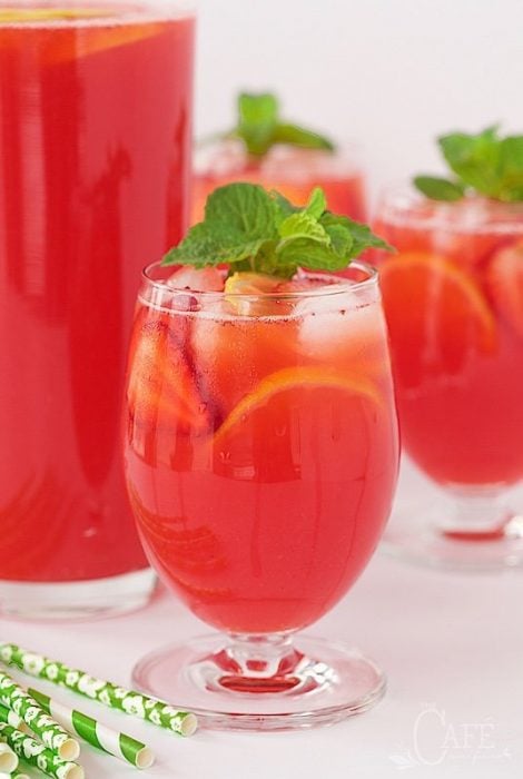 Vertical picture of Strawberry Lemonade in glasses with a pitcher in the background