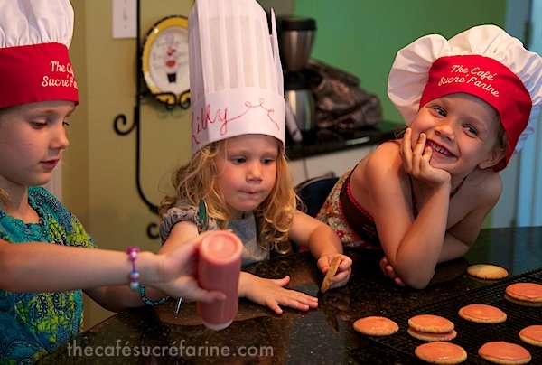 Girls frosting Strawberry Glazed Butter Thins in The Café kitchen.
