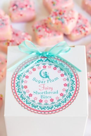 Delicious sugar plum fairy shortbread bites with colorful sprinkles, in a small white box complete with a custom label and ready for gifting.