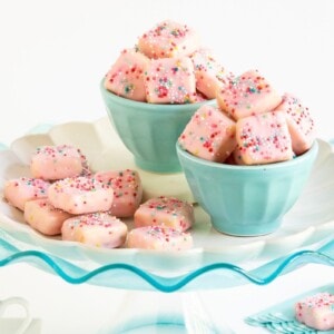 Horizontal photo of Sugar Plum Fairy Shortbread Bites on a turquoise glass pedestal plate.