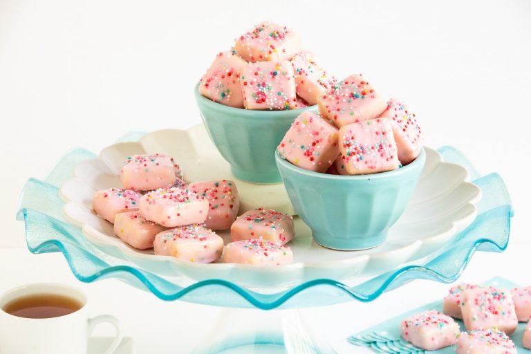 Horizontal photo of Sugar Plum Fairy Shortbread Bites on a turquoise glass pedestal plate.