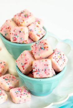 Vertical photo of two turquoise cups filled with Sugar Plum Fairy Shortbread Bites.