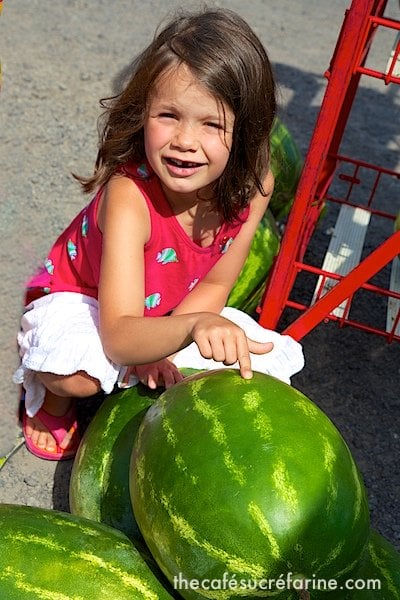 Elle helping to pick out a watermelon for supper at a local farmer's market.