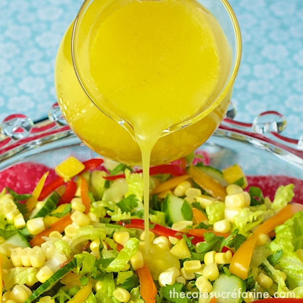 Photo of Sunny Honey Vinaigrette being poured over a platter of Farmer's Market Salad.