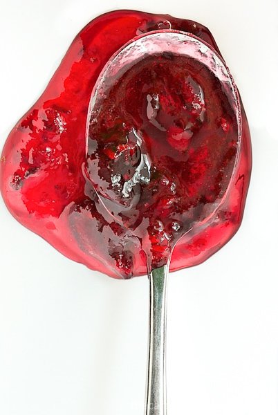 Overhead photo of a spoon overflowing with Sweet Cherry Freezer Jam.
