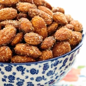 Vertical picture of sweet and spicy almonds in a blue and white bowl