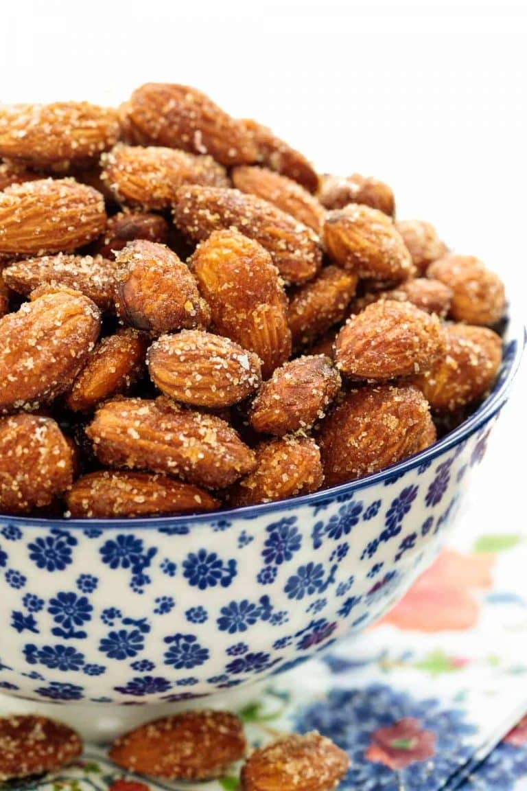 Vertical picture of sweet and spicy almonds in a blue and white bowl