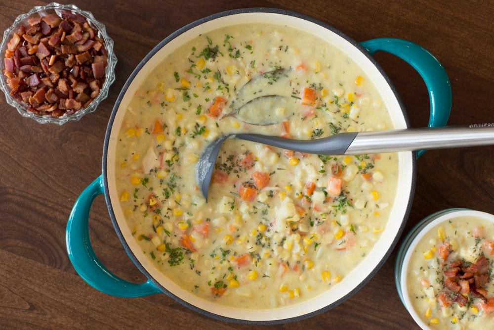 Overhead picture of Turkey Corn Chowder with bacon on a wooden table