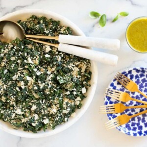 Horizontal overhead photo of a Tuscan Kale Salad with Lemon Basil Dressing on a white marble surface.