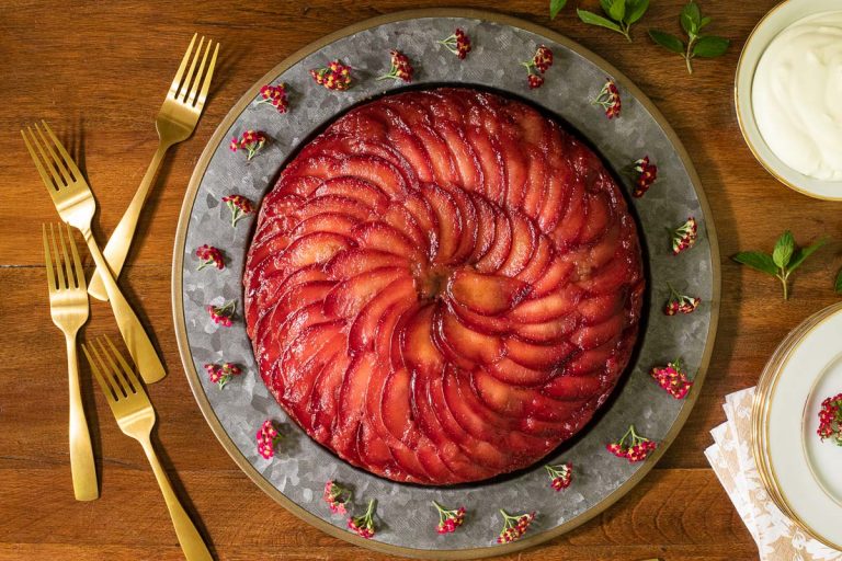 Horizontal overhead photo of an Upside Down Plum Cake on a wood table.