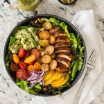 Overhead picture of Warm Chicken and Roasted Potato Salad in a black bowl on a granite counter
