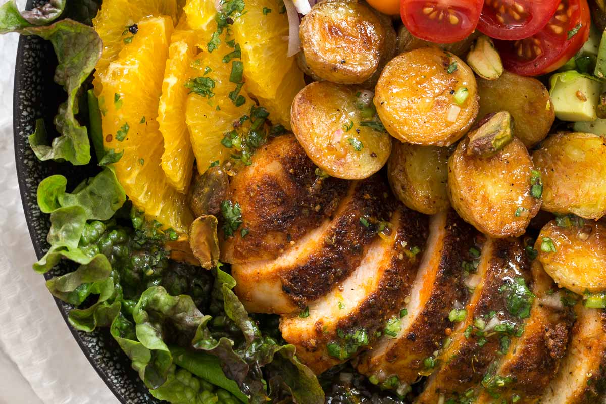 Closeup overhead photo of a Warm Chicken and Roasted Potato Salad, featuring the roasted potatoes and chicken.
