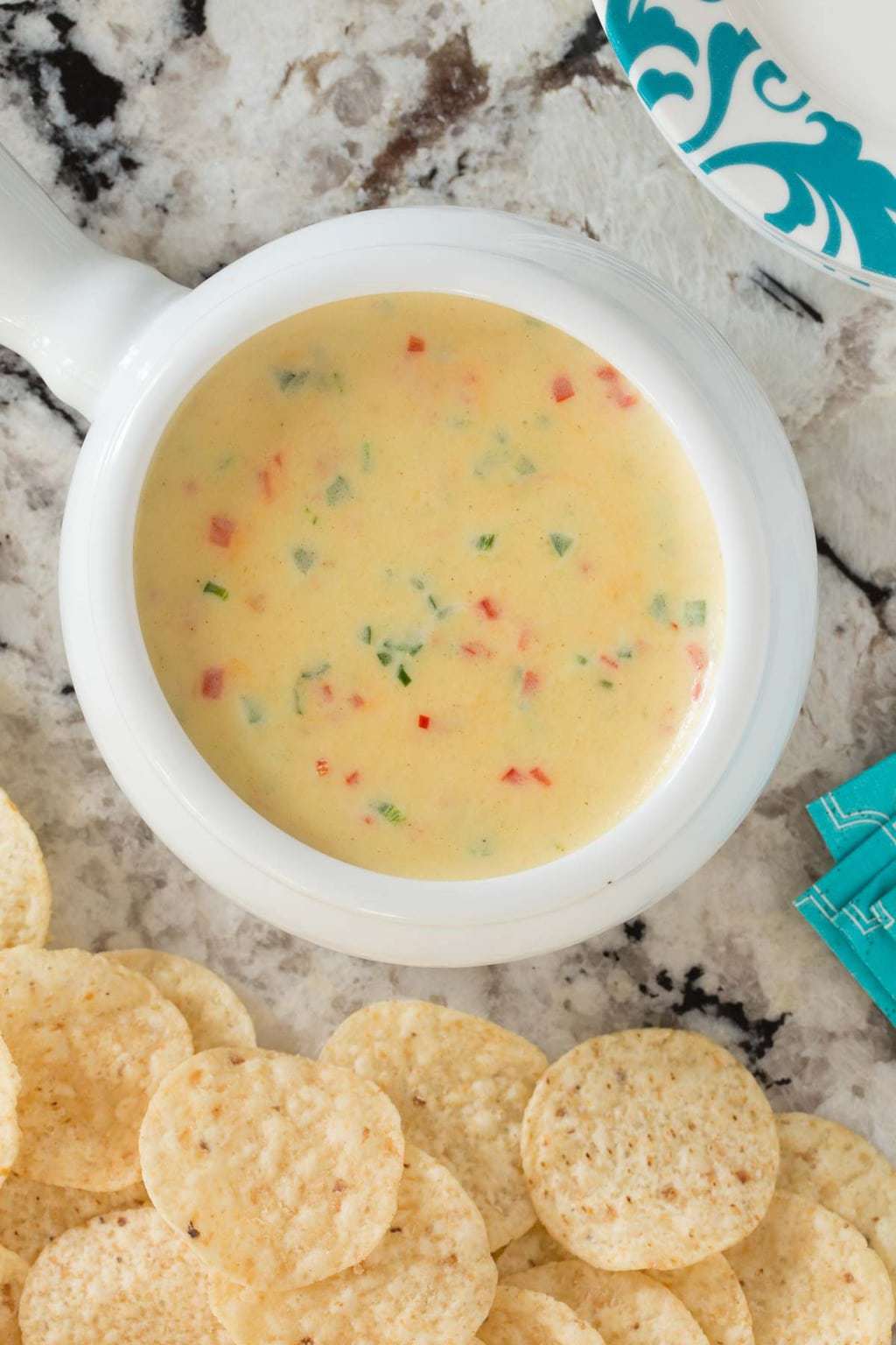 Overhead picture of Warm Jalapeño White Cheddar Dip in a white bowl with tortilla chips