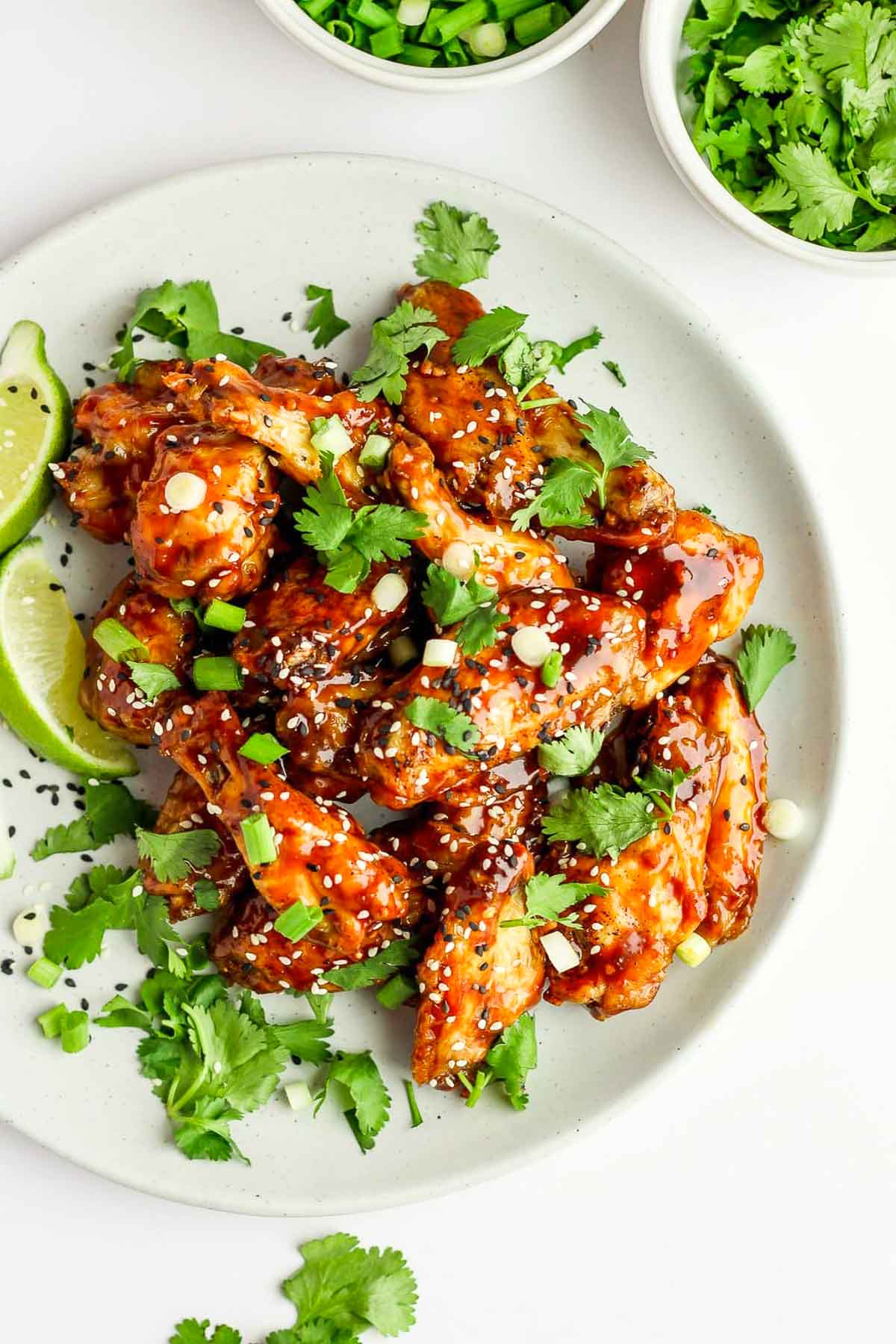 Overhead photo of Easy Ginger Sesame Baked wings garnished with cilantro on a white background.